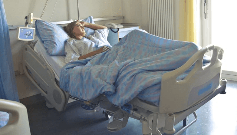Young woman in hospital bed