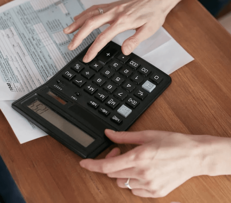 person using a calculator to fill out paperwork