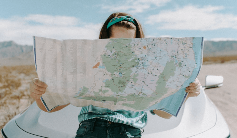 woman looking at a map in the the middle of nowhere lost