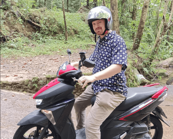 Man riding a rental scooter in Asia
