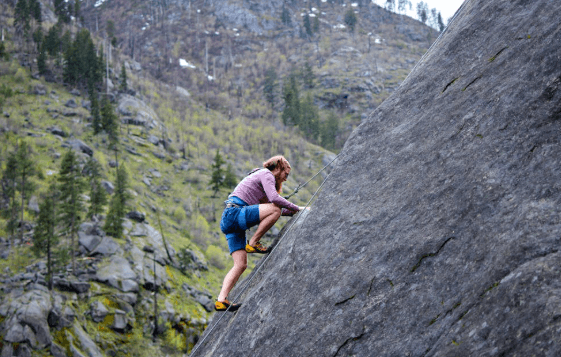 person rock climbing steep rock face